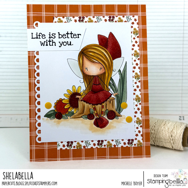 Handmade card design featuring Stamping Bella Whimsabella FlitterFly, Spring Backdrop, and Spec-Tacular Together Sentiment Set cling mounted rubber stamps. The whimsical card showcases a fairy girl with long blonde hair, a large red bow, and a red outfit sitting on a tree stump, surrounded by flowers and leaves. The background includes plaid and floral patterns in orange and white. The sentiment 'Life is better with you.' is prominently displayed. Created by Michele Boyer for the Stamping Bella design team.